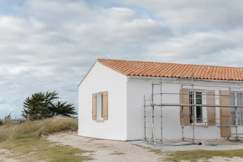 Façade rénovée et échafaudage sur une maison charentaise